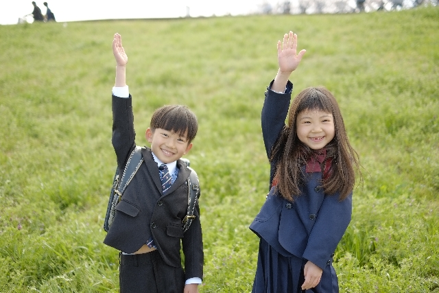 手を挙げる男の子と女の子