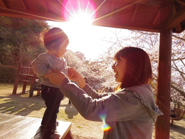 公園のテーブルにいるママと子ども