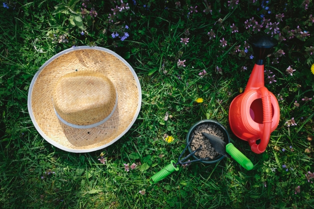 芝生の上の麦わら帽子とガーデニングセット