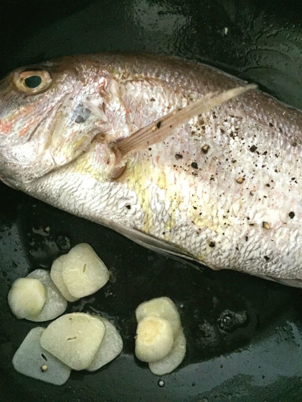 ニンニクと鯛を炒める