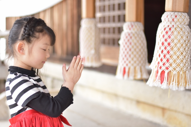 神社にお参りをする女の子