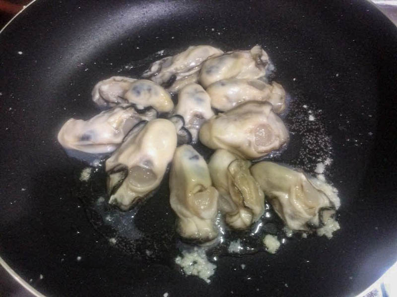 フライパンで牡蠣を炒める