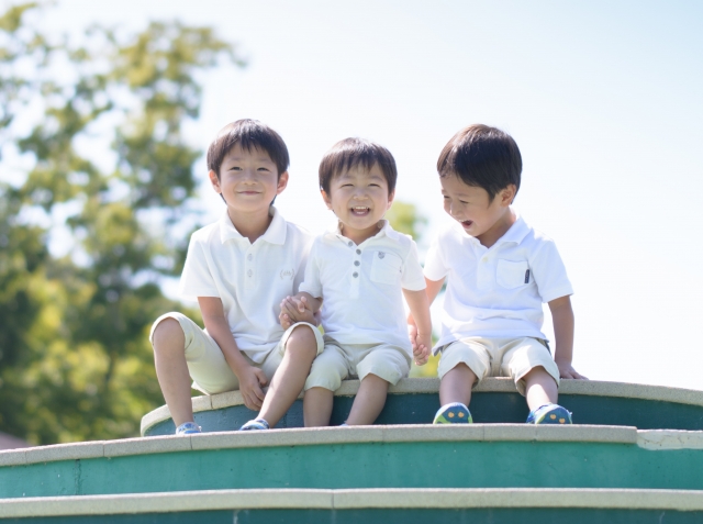 公園の遊具の上の男の子３人