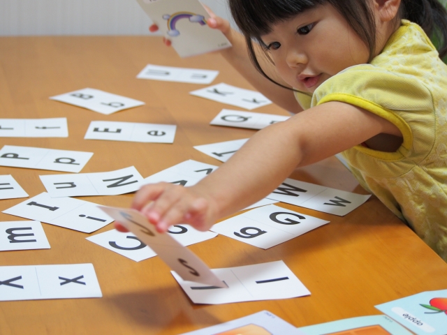 アルファベットのカードで遊ぶ子ども
