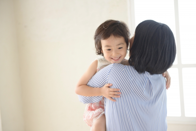 子どもを抱っこするママ