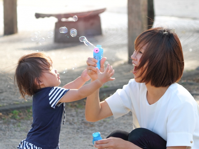 シャボン玉で遊ぶママと子ども