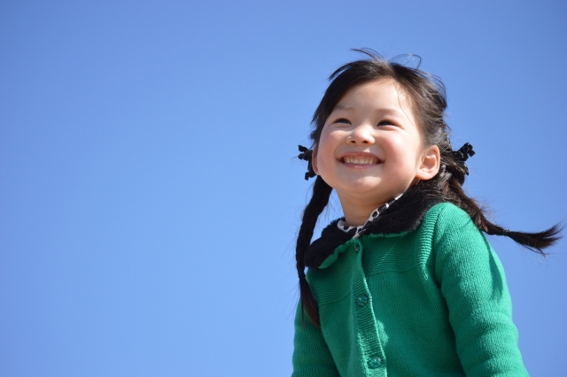 青空バックで笑顔の女の子