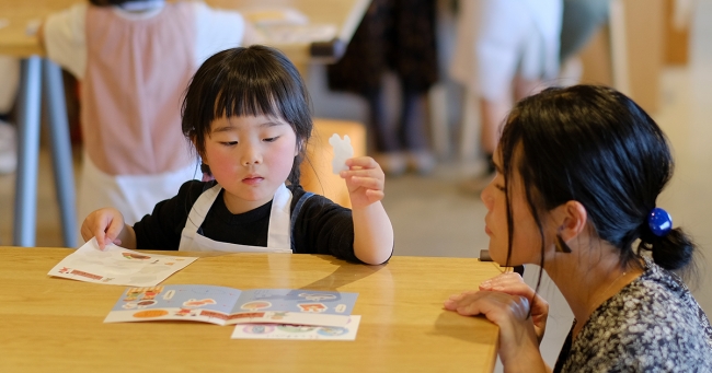 おりょうりえほんを読む親子