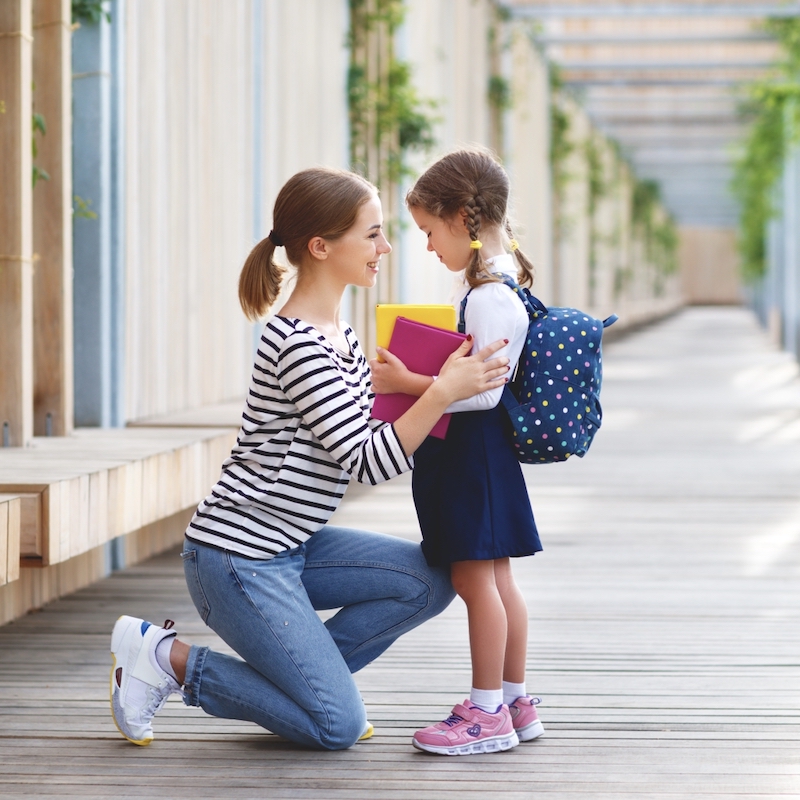 学校での初日。 母は一年生の小さな子供の女子高生を導きます